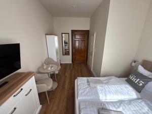 una piccola camera da letto con un letto e una televisione di Süd5 a Borkum
