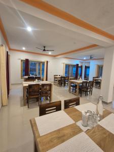 a dining room with tables and chairs and windows at Hunder Nature Retreat in Hundar