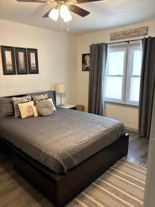 a bedroom with a bed with a ceiling fan and a window at The sunflower stay in Garden City