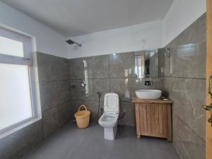 a bathroom with a toilet and a sink at Hunder Nature Retreat in Hundar