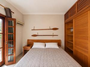 a bedroom with a bed with a wooden headboard at Ilha Flat Apto 3207 in Ilhabela +22 photos