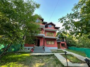 a red brick house with stairs in front of it at The Walnut House in Pahalgām