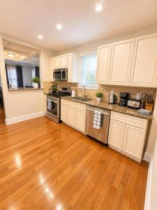 a kitchen with white cabinets and a wooden floor at Stay by Gina in Irvington