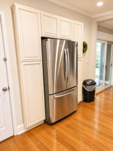 a stainless steel refrigerator in a kitchen with wooden floors at Stay by Gina in Irvington