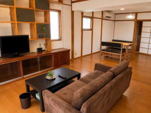ein Wohnzimmer mit Sofa und Tisch in der Unterkunft Rumble Base 山口県光市虹ヶ丘 in Hikari