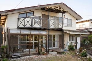 ein Haus mit Glastüren und einem Balkon in der Unterkunft Rumble Base 山口県光市虹ヶ丘 in Hikari