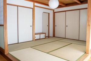 ein leerer Raum mit Glastüren und einem Tisch in der Unterkunft Rumble Base 山口県光市虹ヶ丘 in Hikari