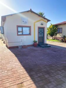 a small white building with a door in a driveway at Windy Dunes Self -Catering Accommodation, Luderitz in Lüderitz
