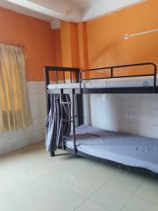 two bunk beds in a room with orange walls at Monica's house in Phnom Penh