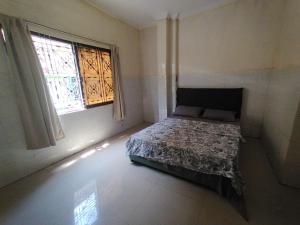 a bedroom with a bed in a room with a window at Monica's house in Phnom Penh