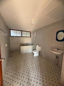 a bathroom with a toilet and a sink at Bann Maii Soi 14 in Ban Hua Khao Sammuk