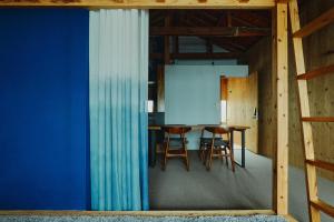 a room with blue walls and a table and chairs at まちの別邸 緝 shu in Kochi