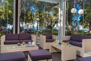 a patio with purple couches and a table and chairs at Hotel Crikvenica in Crikvenica