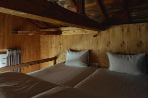 two beds in a room with wooden walls at まちの別邸 緝 shu in Kochi