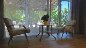 a table with two chairs and a vase with a plant at Kernavės centras in Kernavė