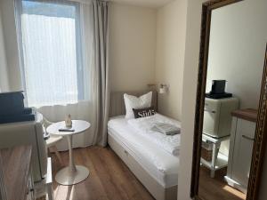 una piccola camera da letto con un letto e uno specchio di Süd5 a Borkum