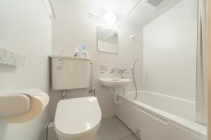a white bathroom with a toilet and a sink at コインズホステル天神ペット宿泊可 in Fukuoka