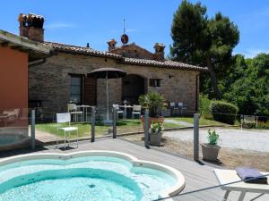 an outdoor hot tub in front of a house at Flat on a farm with swimming pool and many activities in SantʼAngelo in Vado