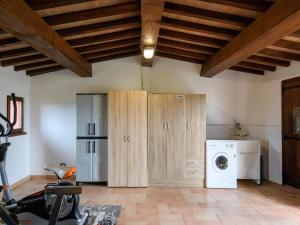 a laundry room with wooden cabinets and a washer and dryer at Flat on a farm with swimming pool and many activities in SantʼAngelo in Vado