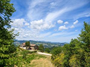 a house on top of a hill with trees at Flat on a farm with swimming pool and many activities in SantʼAngelo in Vado