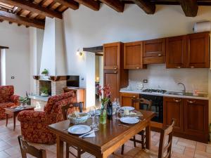 a kitchen with a wooden table and chairs and a kitchen with a stove at Apartment in Sant'Angelo near Medieval Town in SantʼAngelo in Vado
