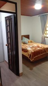 a bedroom with a bed and an open door at Hotel Los alpes in Garagoa