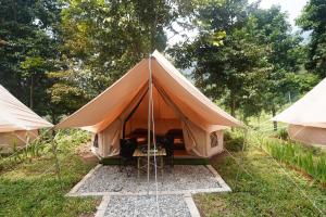 a large tent is set up in the grass at Kabut Pinus Comfort Camp in Palasari