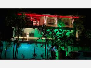 a building with green and red lights at night at The Grand Crest Residency in Panchgani +26 photos