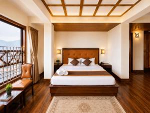 a bedroom with a large bed and a balcony at Gangtok Central Rooms in Gangtok