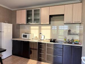 a kitchen with brown cabinets and a white microwave at Котедж в горах у Антоніни in Solochyn