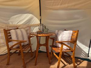 two chairs and a table in a tent at Sunset Tent in Sageau