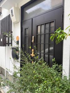 a black door on a white house with plants at WUMETEI Japanese-style lodge in Kyoto