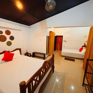 a bedroom with a large bed and a room with a tub at Orchid Resort in Medawachchiya