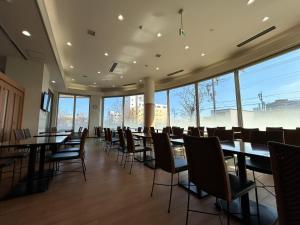 a conference room with tables and chairs and large windows at Lasting Hotel in Kushiro