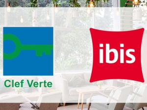 a red pillow with the ibis logo on it next to a window at Ibis Saint-Genis-Pouilly Genève in Saint-Genis-Pouilly