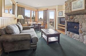 a living room with a couch and a stone fireplace at Superior Shores Resort in Two Harbors