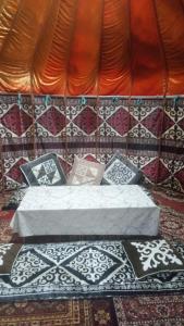 a bed with pillows on the floor in a room at KochevniK in Almaty