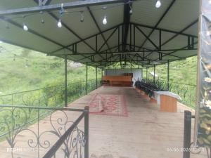 a room with a table and benches on a balcony at KochevniK in Almaty