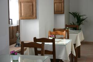 a dining room with a white table and chairs at Hostal Santa María de Úbeda in Úbeda