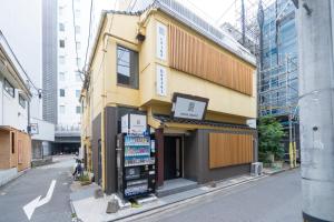 a yellow building on the side of a street at コインズホステル天神ペット宿泊可 in Fukuoka