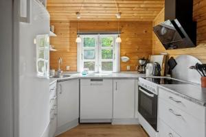 a kitchen with white appliances and a wooden wall at 3032-Stege-Ankeret-4 in Stege