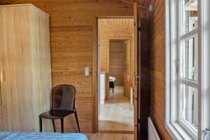 a bedroom with a chair and a door to a hallway at 3032-Stege-Ankeret-4 in Stege +15 photos