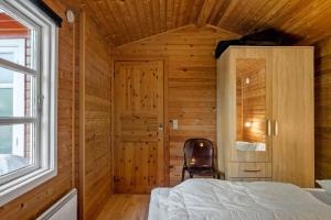 a bedroom with a bed and a chair next to a window at 3032-Stege-Ankeret-4 in Stege