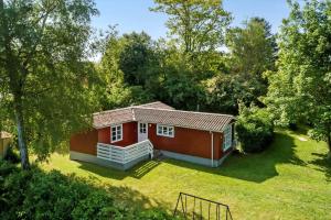 a small red house in the middle of a yard at 3032-Stege-Ankeret-4 in Stege