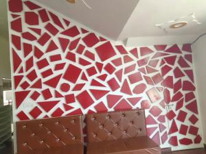 a room with a red and white patterned wall at BRAHMANCHAL guest house in Barsāna