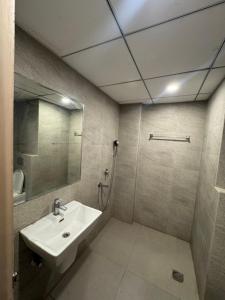 a bathroom with a sink and a shower with a mirror at the Aurelia estate studio apartment Alpha 2 in Greater Noida +7 photos