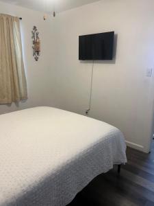 a bedroom with a bed and a flat screen tv on the wall at Near Red Mountain park in Mesa