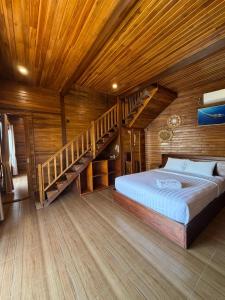 a bedroom with a large bed and a staircase at Garuda Dive & Accomodation Nusa Penida in Nusa Penida
