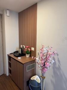 a room with a desk with a vase of flowers at the Aurelia estate studio apartment Alpha 2 in Greater Noida