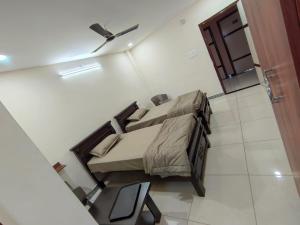 a small bedroom with a bed and a chair at Hotel N Pride in Guntūr
